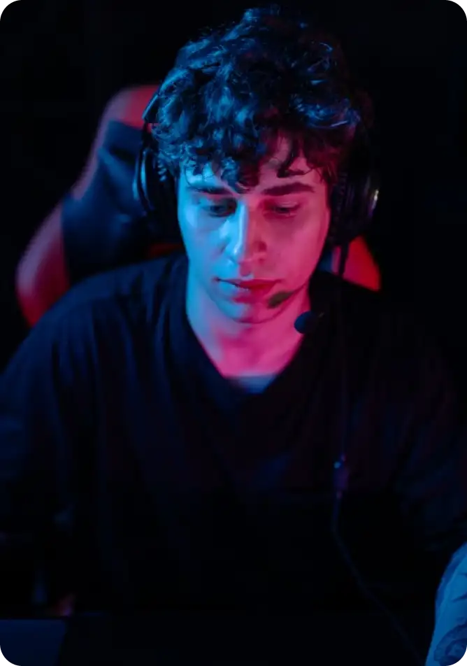 Portrait of a focused esports player illuminated by blue and red neon lighting.